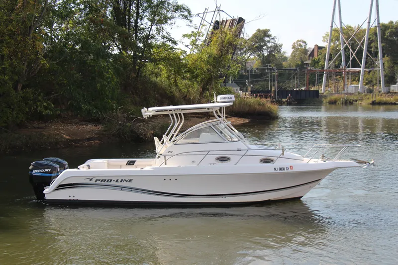 Slide: The Image of 2005 Pro-Line 29 Express boat on a calm river with trees in the background. - 16