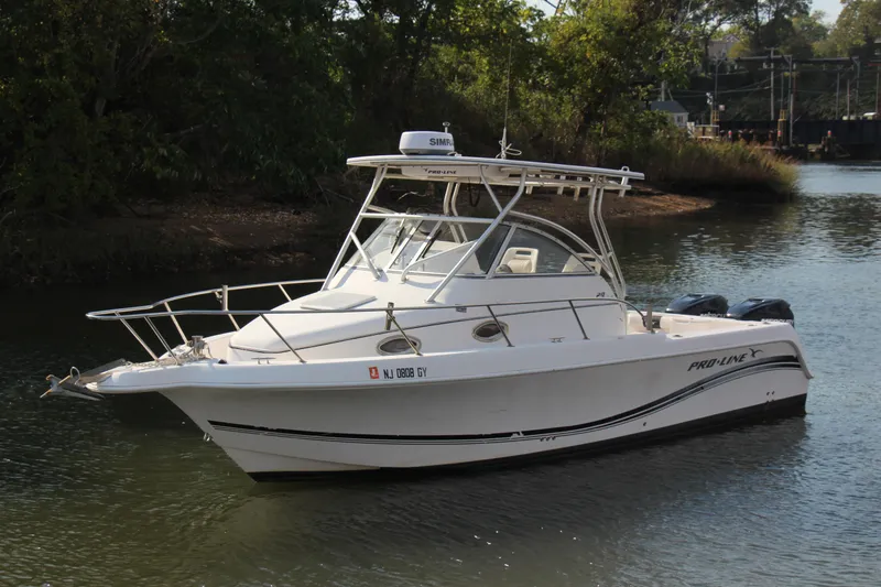 Slide: The Image of 2005 Pro-Line 29 Express boat on calm water, surrounded by greenery. - 19