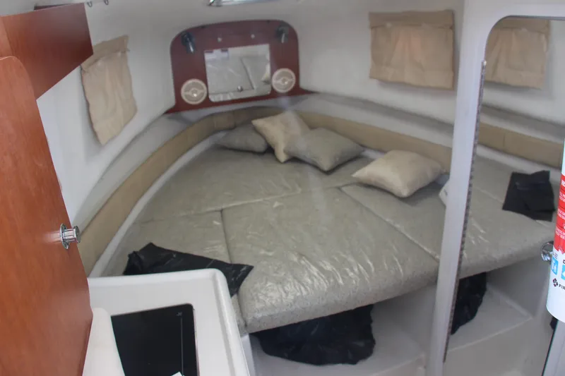 Slide: The Image of 2005 Pro-Line 29 Express cabin interior with bed, pillows, and compact design. - 7