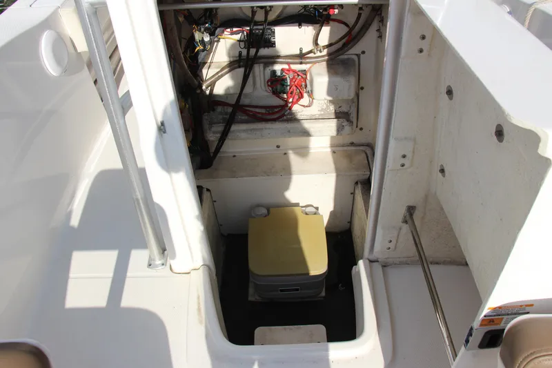 Slide: The Image of 2017 Robalo R200ES boat storage compartment with wiring and portable toilet. - 15