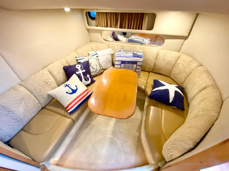 Slide: The Image of Interior of 2006 Chaparral Signature 350 with cozy seating and nautical-themed cushions. - 23