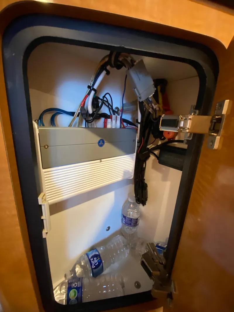 Slide: The Image of Electrical panel inside 2006 Chaparral Signature 350 boat cabinet with water bottles. - 25