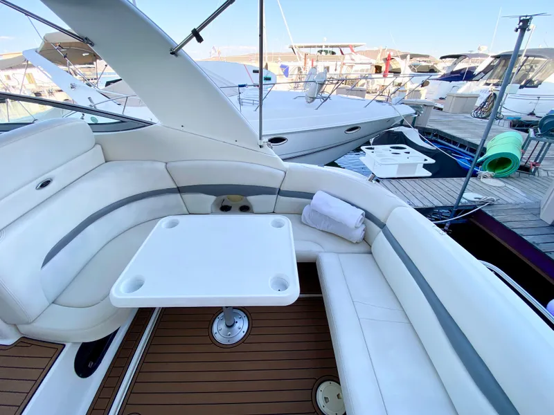 Slide: The Image of 2006 Chaparral Signature 350 yacht interior with white seating and table at marina. - 31