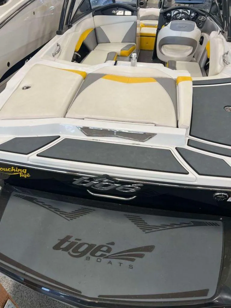 Slide: The Image of 2015 Tigé R20 boat interior with gray and yellow seating, dashboard, and branding. - 4