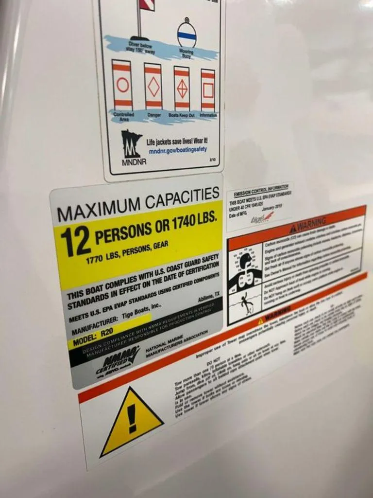 Slide: The Image of 2015 Tigé R20 capacity label, maximum 12 persons or 1740 lbs, safety compliance details. - 6