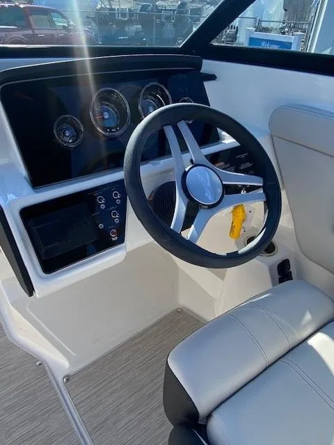 Slide: The Image of 2025 Sea Ray SPX 230 boat interior with steering wheel and dashboard controls. - 10
