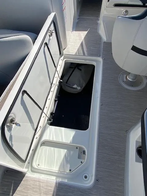 Slide: The Image of 2025 Sea Ray SPX 230 boat interior storage compartment open, showing spacious design. - 14
