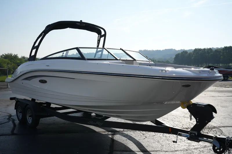 Slide: The Image of 2025 Sea Ray SPX 230 boat on trailer, parked outdoors, under clear sky. - 2