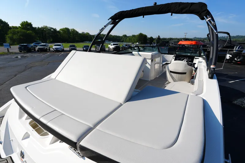 Slide: The Image of 2025 Sea Ray SPX 230 boat with spacious seating and sleek design in a parking lot. - 25
