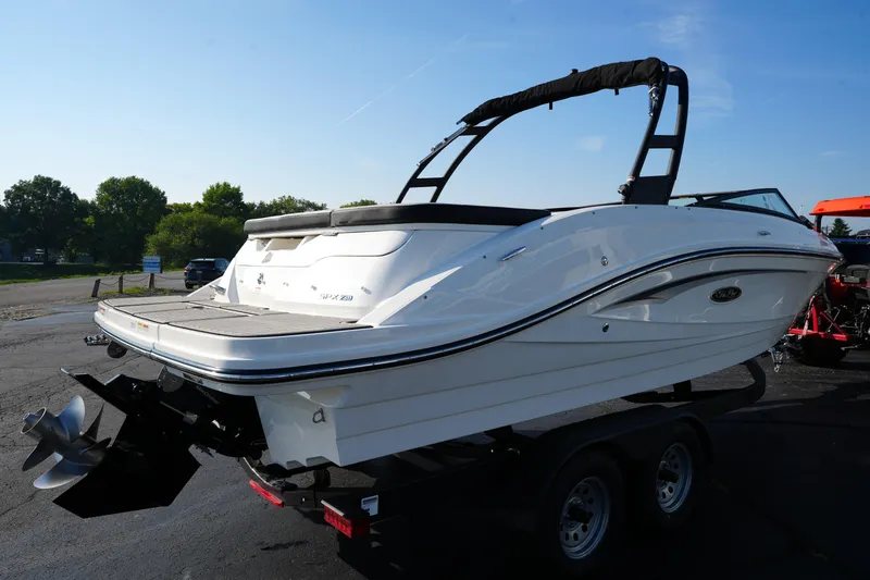 Slide: The Image of 2025 Sea Ray SPX 230 boat on trailer, parked outdoors under clear sky. - 5
