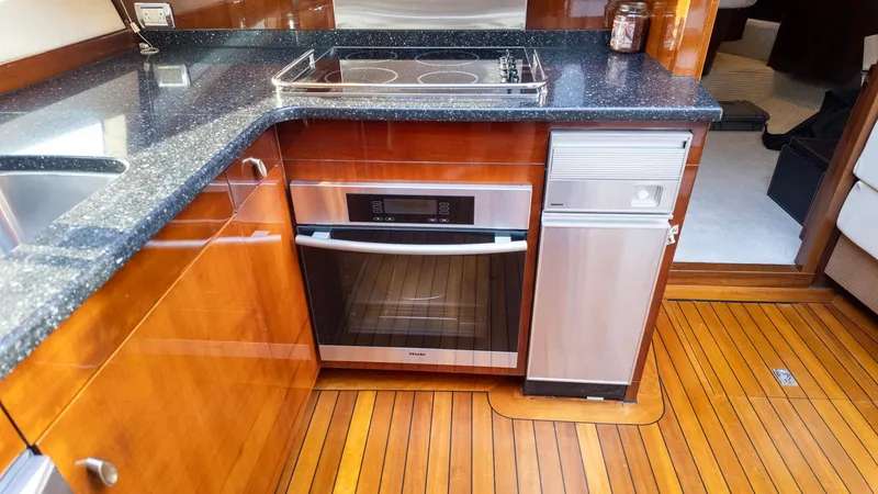 Slide: The Image of Luxurious kitchen in 2008 Savannah 54 yacht with modern appliances and wooden flooring. - 25
