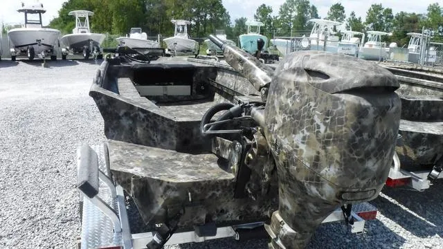Slide: The Image of 2025 Excel Boats Viper F4 1751 with camouflage design on a trailer in a boatyard. - 3