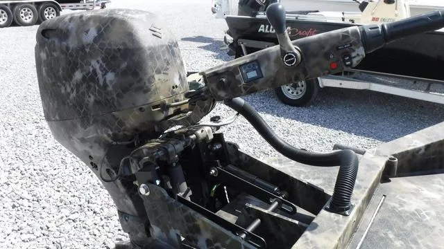 Slide: The Image of 2025 Excel Boats Viper F4 1751 outboard motor in camouflage design on gravel surface. - 5