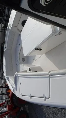 Slide: The Image of 2023 Blue Wave 2800 Makaira boat interior with white seating and storage compartments. - 10