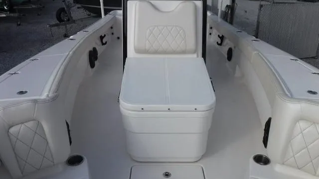Slide: The Image of 2023 Blue Wave 2800 Makaira boat interior with white seating and storage. - 17