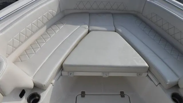 Slide: The Image of 2023 Blue Wave 2800 Makaira boat interior with cushioned seating and diamond stitching. - 22