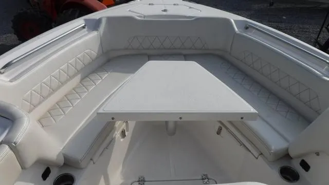 Slide: The Image of 2023 Blue Wave 2800 Makaira boat interior with cushioned seating and table. - 23