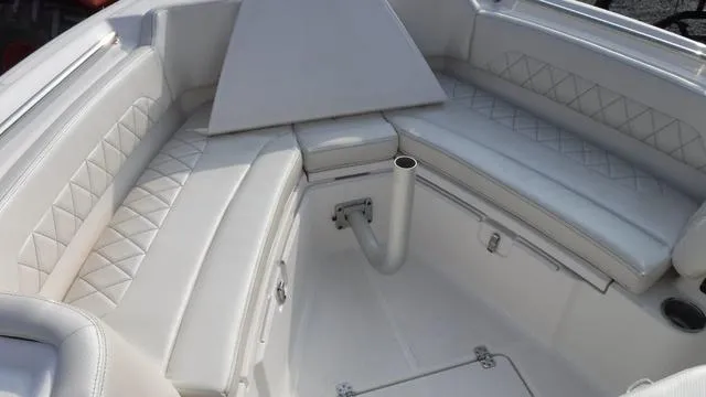 Slide: The Image of 2023 Blue Wave 2800 Makaira boat interior with white cushioned seating and storage. - 24