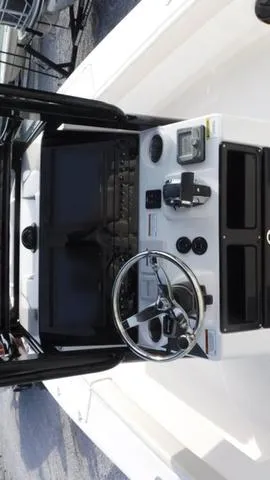 Slide: The Image of 2023 Blue Wave 2800 Makaira boat dashboard with steering wheel and controls. - 28