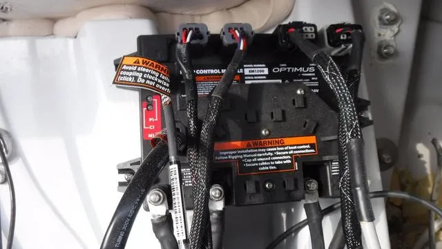 Slide: The Image of 2023 Blue Wave 2800 Makaira boat control panel with warning labels and cables. - 37