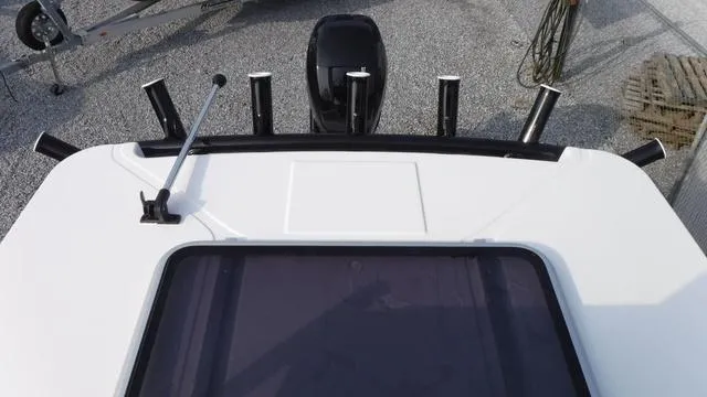Slide: The Image of 2023 Blue Wave 2800 Makaira boat deck with rod holders and outboard motor. - 49