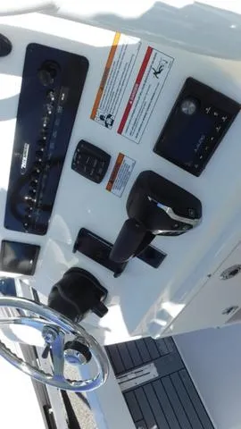 Slide: The Image of 2024 Pathfinder 2600 TRS boat dashboard with steering wheel and control panel. - 17