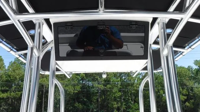 Slide: The Image of 2024 Bulls Bay 2200 boat with T-top and electronics box, set against a forested background. - 18