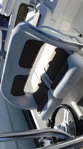 Slide: The Image of 2013 ShearWater 25 Bay boat interior with cushioned seating and steering wheel. - 18