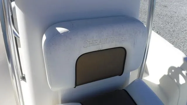 Slide: The Image of 2013 ShearWater 25 Bay boat seat with embossed logo, white and brown upholstery. - 24