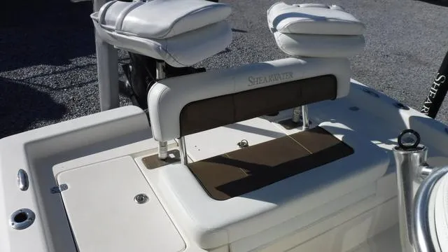 Slide: The Image of 2013 ShearWater 25 Bay boat seating area with cushioned backrest and storage. - 25