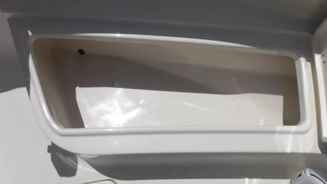 Slide: The Image of Bulls Bay 255 CC 2025 boat storage compartment, white interior, close-up view. - 12