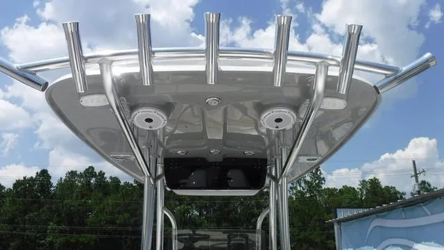 Slide: The Image of 2025 Bulls Bay 255 CC boat T-top with rod holders against a blue sky. - 22