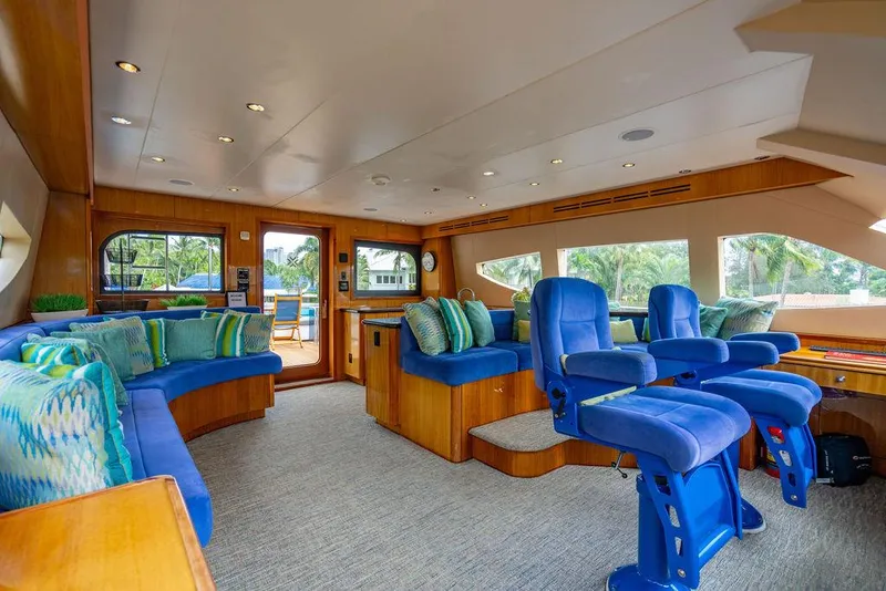 Slide: The Image of Luxurious interior of 2007 Hatteras Enclosed Flybridge with blue seating and wood accents. - 12