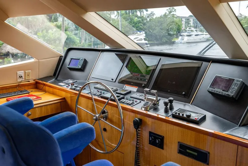 Slide: The Image of 2007 Hatteras Enclosed Flybridge helm with modern navigation equipment and blue captain's chair. - 13