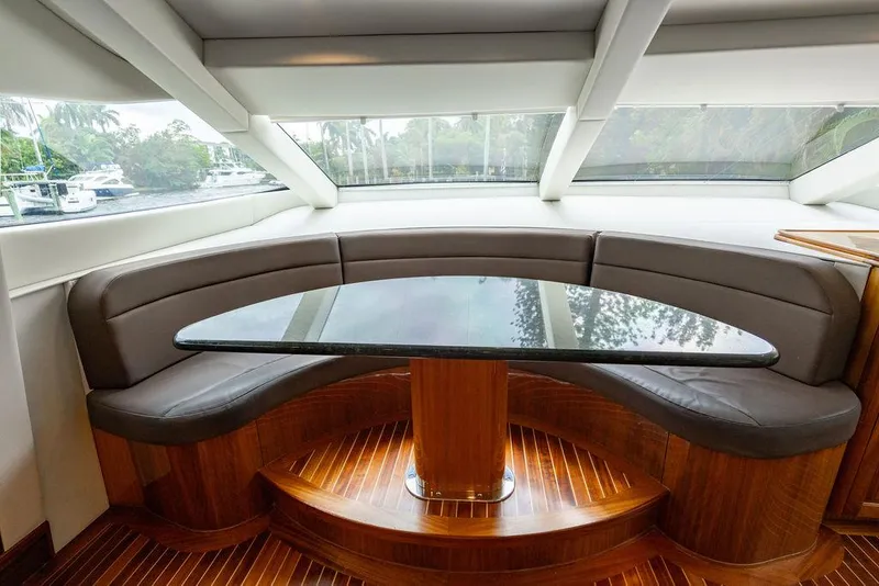 Slide: The Image of 2007 Hatteras Enclosed Flybridge interior with curved seating and glass table. - 11