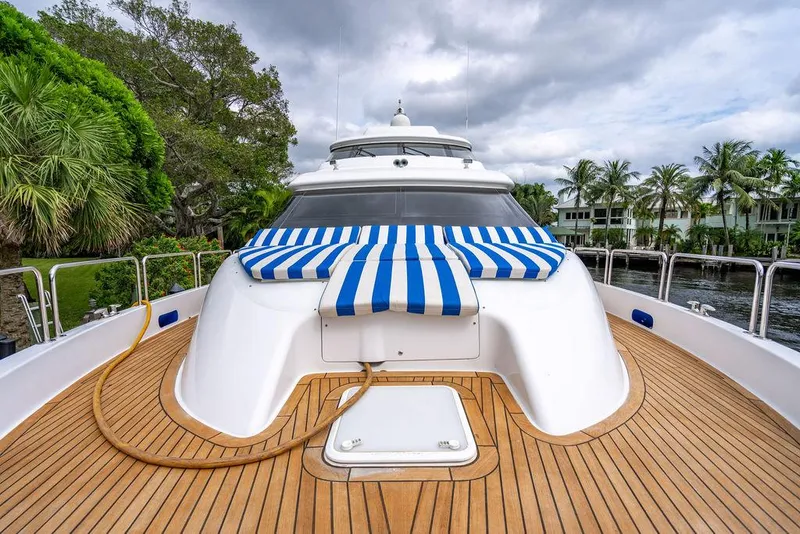 Slide: The Image of 2007 Hatteras Enclosed Flybridge yacht with striped sunbed on teak deck. - 30
