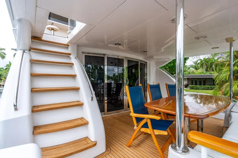 Slide: The Image of 2007 Hatteras Enclosed Flybridge yacht with teak deck, outdoor dining area, and staircase. - 5