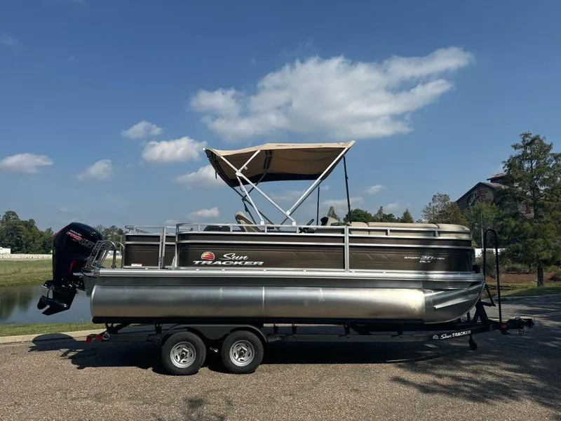 Slide: The Image of 2025 Sun Tracker SportFish 20 DLX pontoon boat on trailer, parked outdoors. - 2