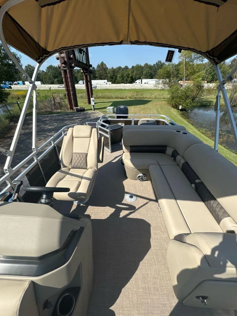 Slide: The Image of 2025 Sun Tracker SportFish 20 DLX pontoon boat with beige seating and canopy. - 5