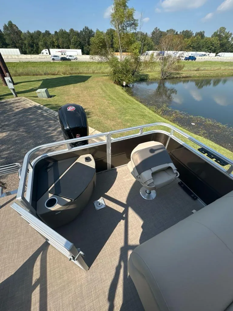 Slide: The Image of 2025 Sun Tracker SportFish 20 DLX pontoon boat by a scenic lake. - 6