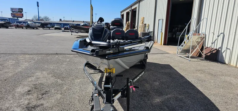 Slide: The Image of 2025 Tracker Pro Team 175 Crappie Edition boat on trailer outside a warehouse. - 2