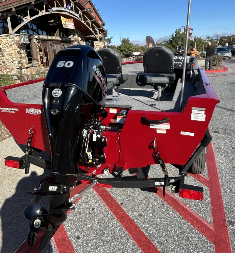 Slide: The Image of 2025 Tracker Pro Guide V-16 SC boat with 50 HP Mercury engine, parked outdoors. - 2