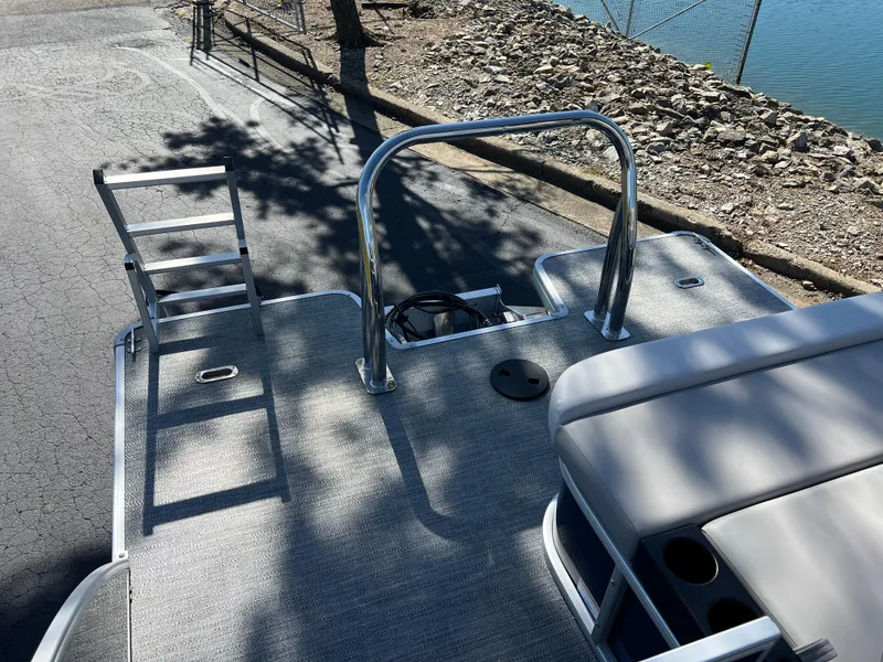 Slide: The Image of 2025 Godfrey Xperience 2286 SFL boat deck with seating and ladder by the water. - 16
