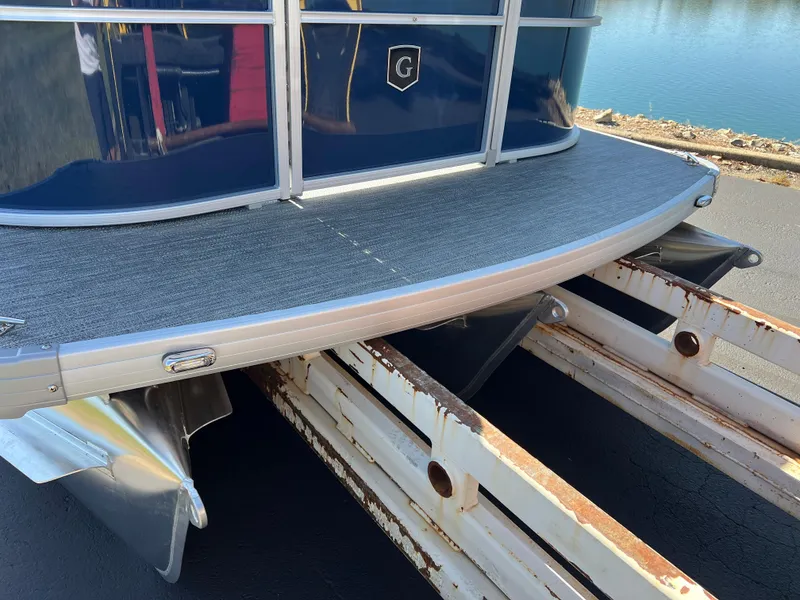 Slide: The Image of 2025 Godfrey Xperience 2286 SFL pontoon boat on trailer, near water. - 25