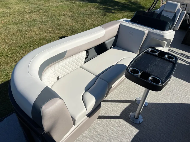 Slide: The Image of 2025 Godfrey SWEETWATER 2286 SFL boat interior with plush seating and cupholder table. - 11