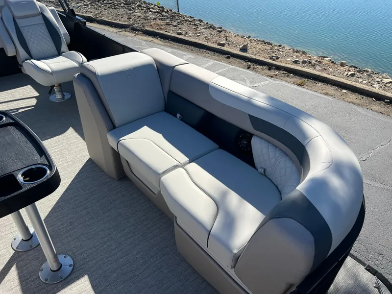 Slide: The Image of 2025 Godfrey SWEETWATER 2286 SFL boat interior with plush seating by the water. - 12