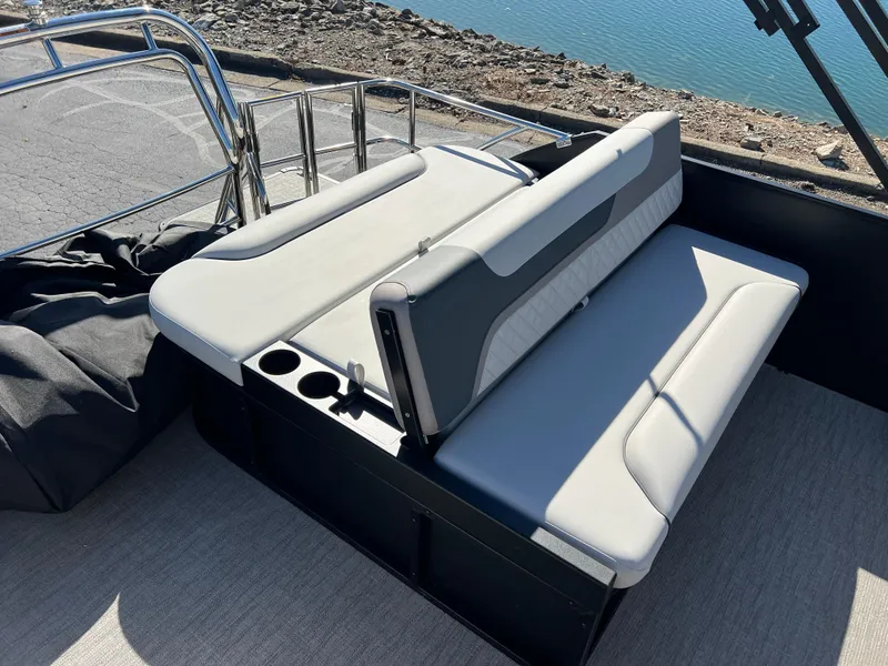Slide: The Image of 2025 Godfrey SWEETWATER 2286 SFL boat seating with cup holders, near water. - 17