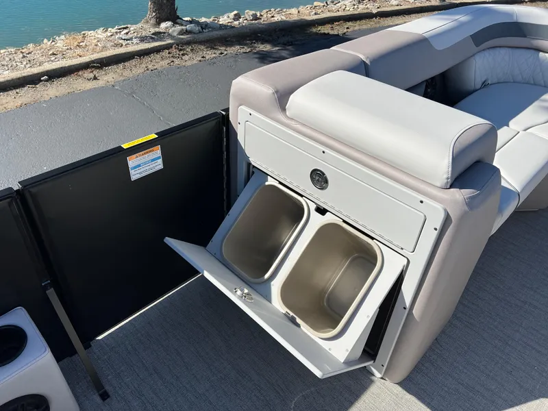 Slide: The Image of 2025 Godfrey SWEETWATER 2286 SFL boat interior with open storage compartment by the water. - 25