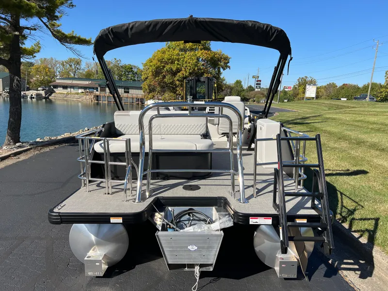 Slide: The Image of 2025 Godfrey SWEETWATER 2286 SFL pontoon boat docked by a lakeside. - 3