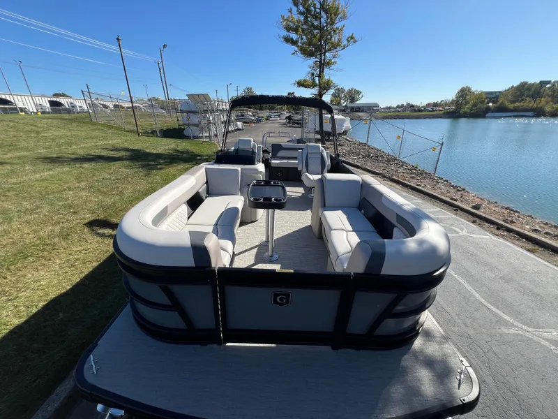 Slide: The Image of 2025 Godfrey SWEETWATER 2286 SFL pontoon boat docked by a serene lake. - 9